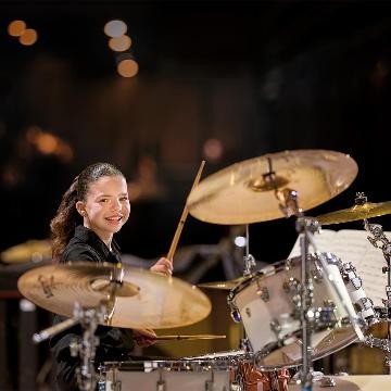 Schlagzeugspielerin lächelt in die Kamera Schlagzeugspielerin lächelt in die Kamera