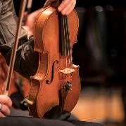 Eine Geige wird von einem Schüler auf dem Bein abgestützt Eine Geige wird von einem Schüler auf dem Bein abgestützt