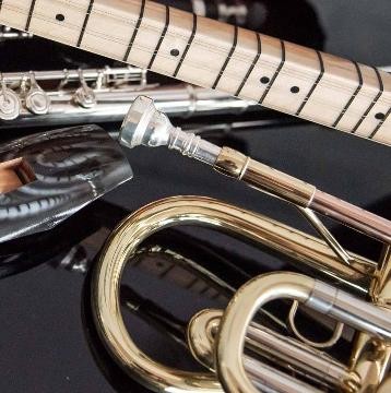 verschiedene Instrumente liegen auf einem Tisch, unter anderem eine Trompete und Flöte verschiedene Instrumente liegen auf einem Tisch, unter anderem eine Trompete und Flöte