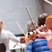 Orchesteraufnahme mit Fokus auf Geigenspielern Orchesteraufnahme mit Fokus auf Geigenspielern