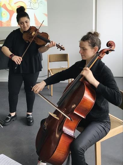 Zwei Lehrerinnen spielen ihre Instrumente. Eine Cello und eine Geige
