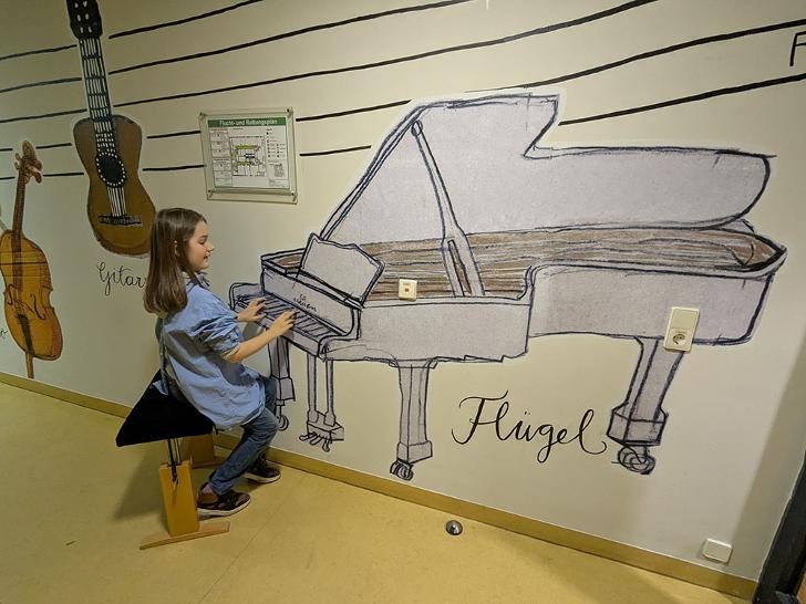 Junge bespielt den an die Wand gemalten Flügel