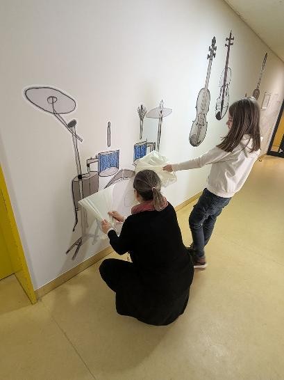 Junge und Frau ziehen Folie von der Wand ab