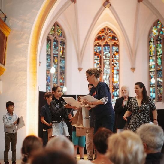 Kinder bekommen in der Kirche ihre Urkunden ausgehändigt