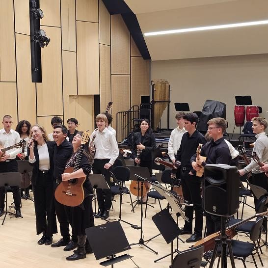 Schülerinnen und Schüler stehend mit ihren Gitarren