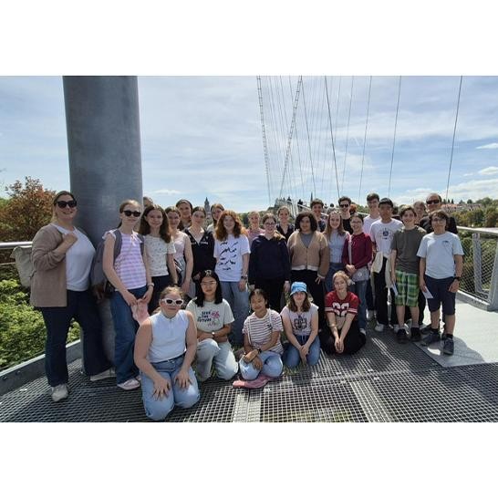 Eine Gruppe Jugendlicher stehen und knien auf einer Brücke